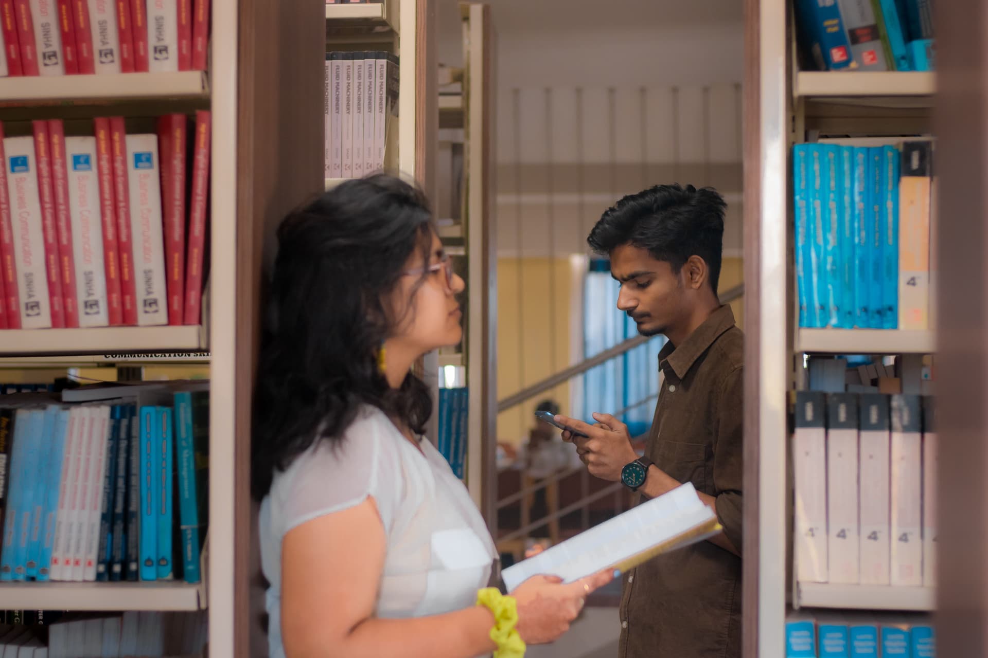 Estudiantes consultando material académico en una biblioteca en India